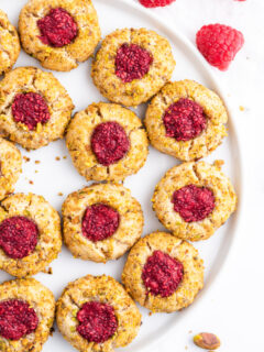 raspberry pistachio thumbprint cookies on a platter