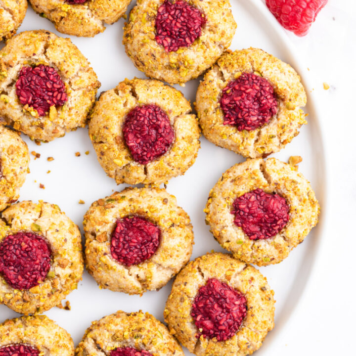 raspberry pistachio thumbprint cookies on a platter
