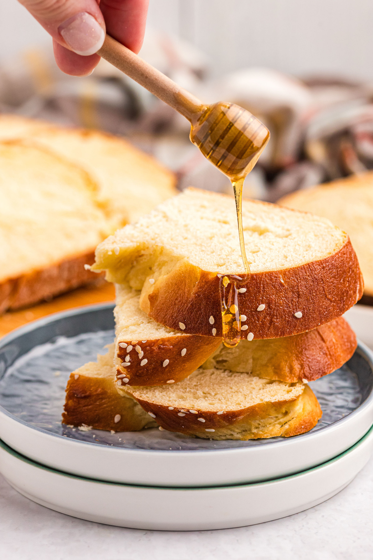 pouring honey on slices of challah