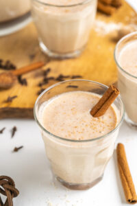 coquito in glass with cinnamon stick garnish