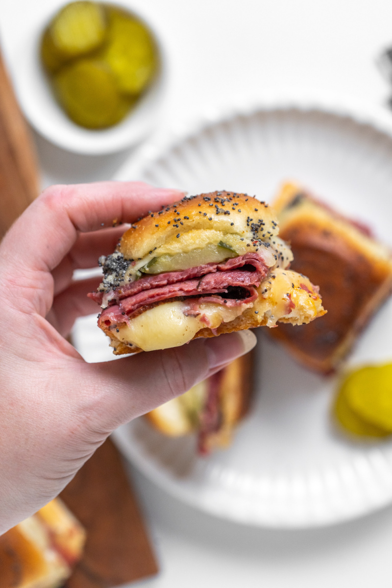 hand holding hot pastrami slider