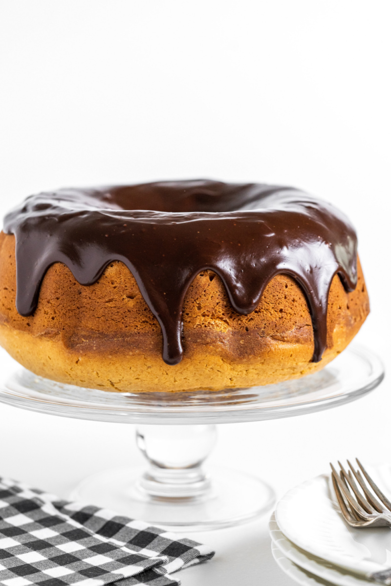 peanut butter bundt cake on a cake stand with chocolate glaze