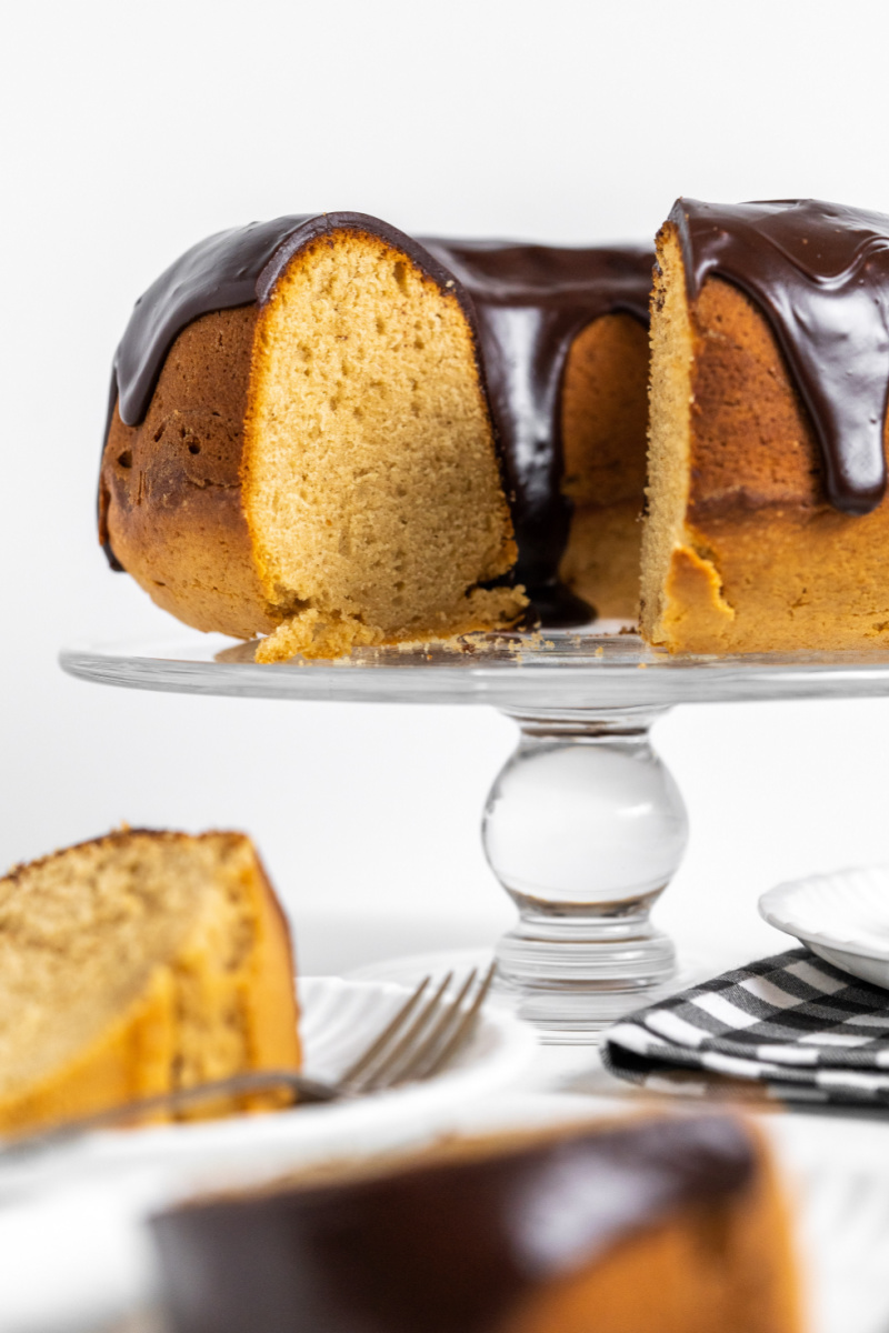 peanut butter bundt cake sliced into on cake stand