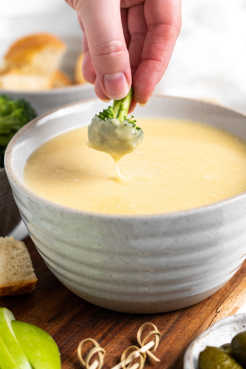 dunking broccoli into cheese fondue