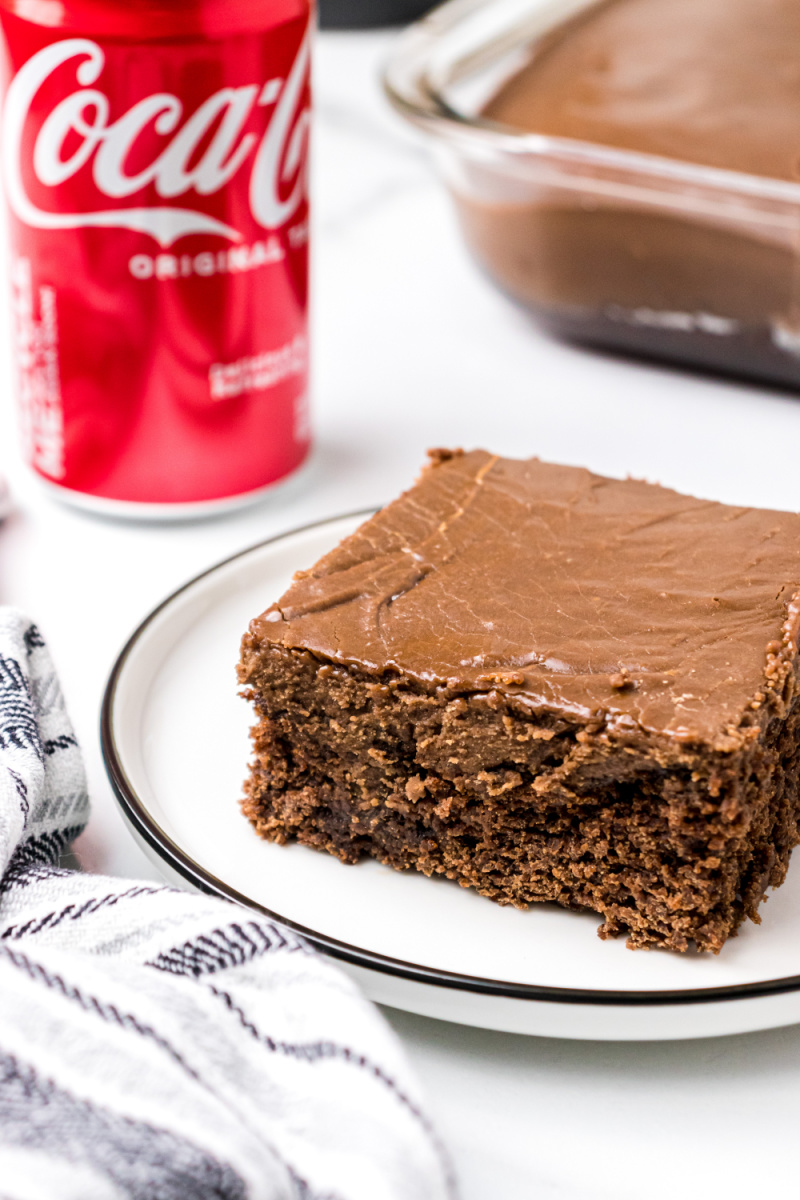 slice of coca cola cake on a plate with coke in background