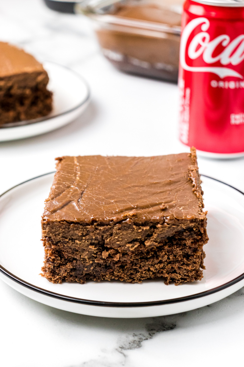 slice of coca cola cake on a plate with coke in background