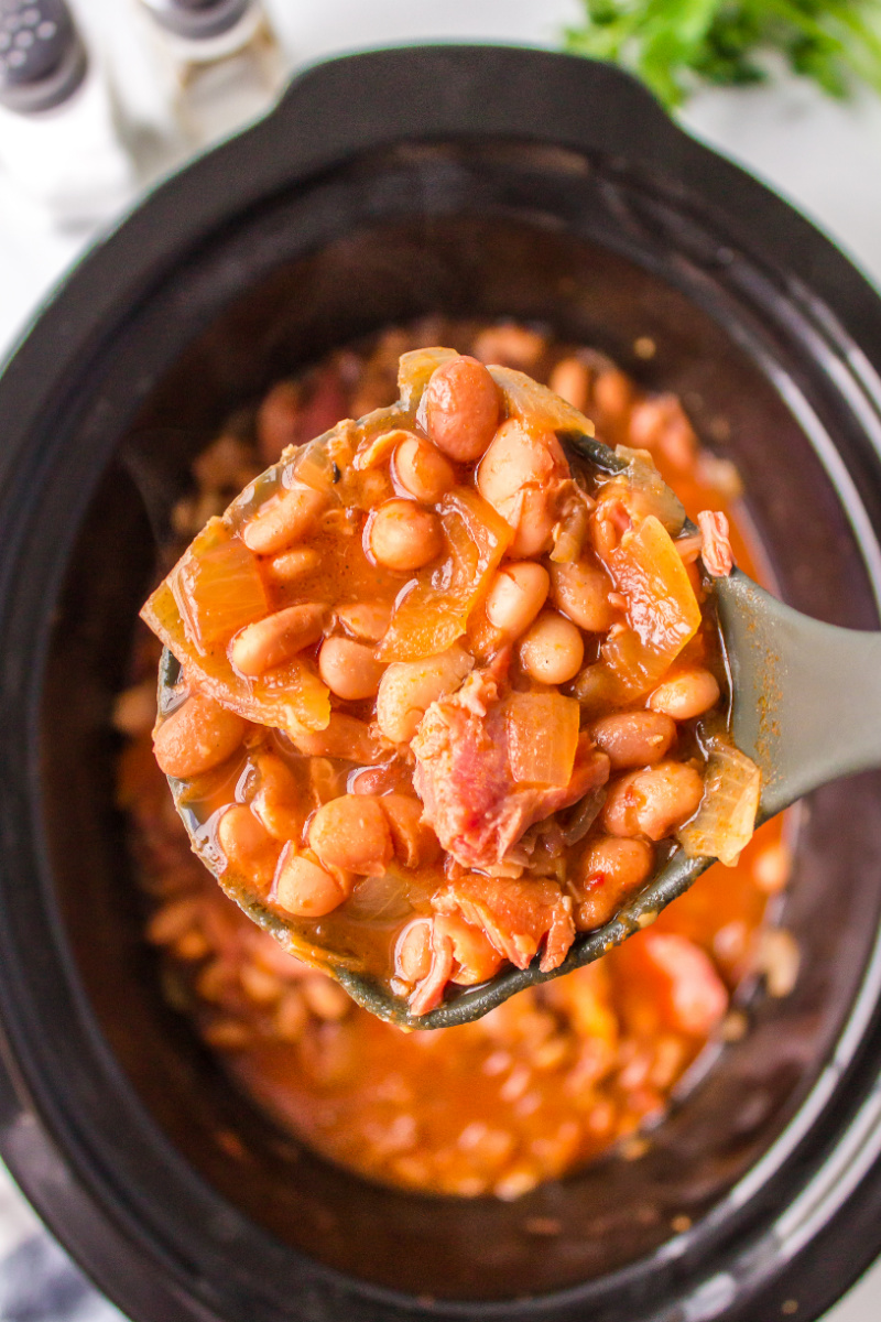 spooning dude ranch beans out of slow cooker
