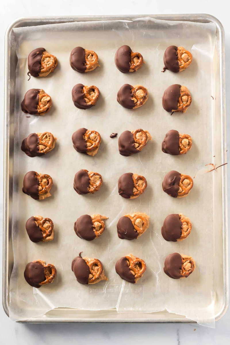 baking sheet with chocolate dipped peanut butter pretzels