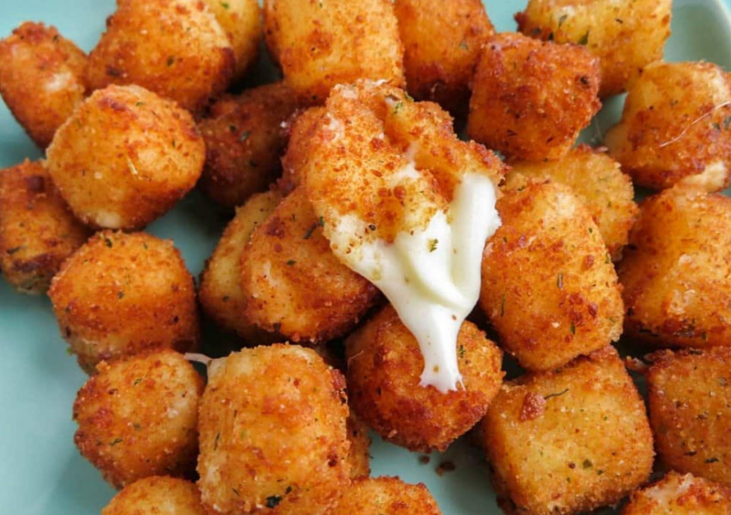 fried cheese bites with one broken open to see cheese