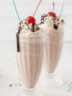 two chocolate milkshakes with straws