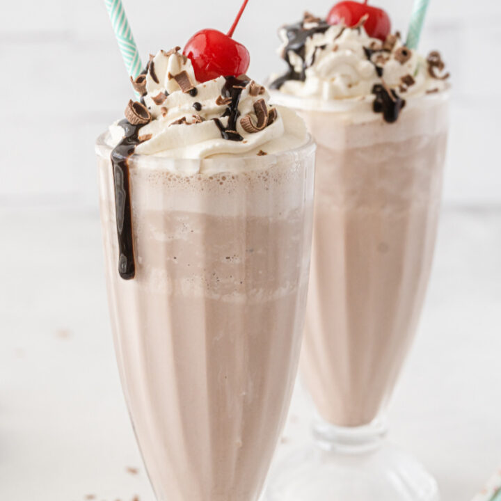 two chocolate milkshakes with straws