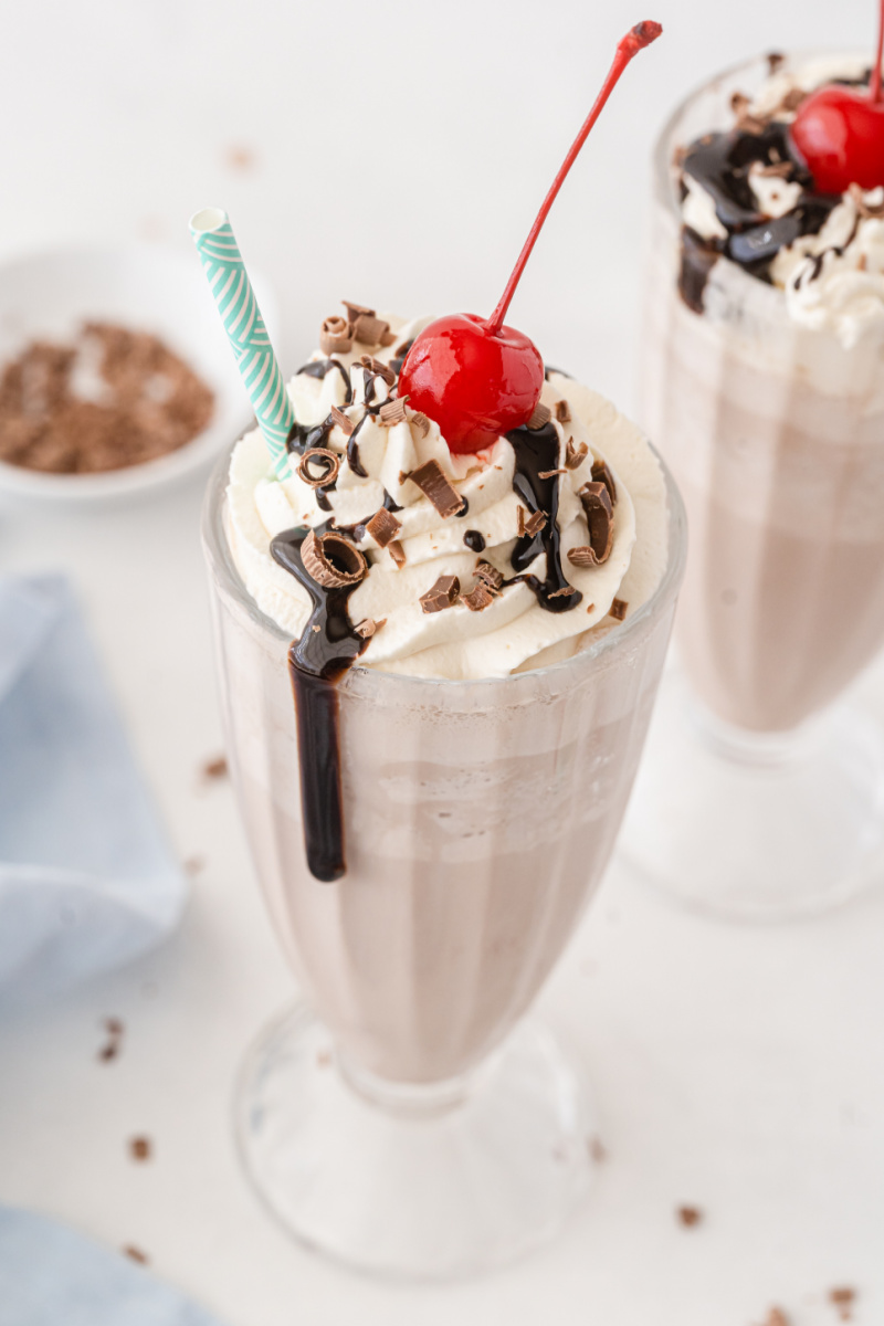 chocolate milkshake with chocolate sauce cherry and straw