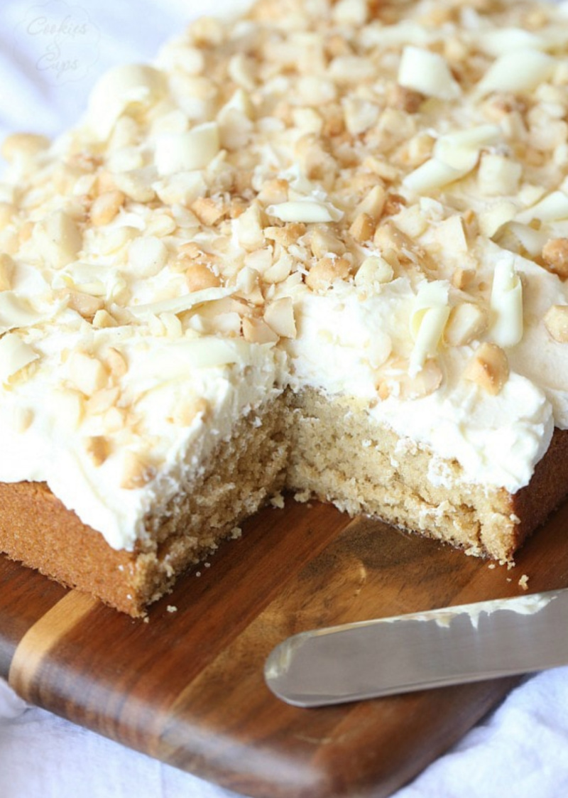 white chocolate macadamia nut cake with slice taken out of it