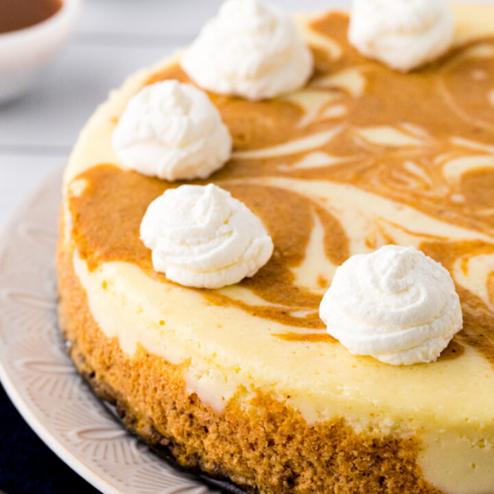 layered pumpkin cheesecake with whipped cream on top