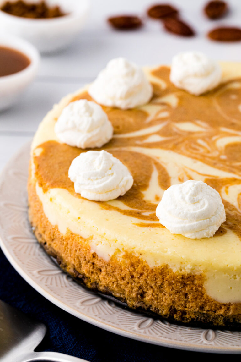 layered pumpkin cheesecake with whipped cream on top