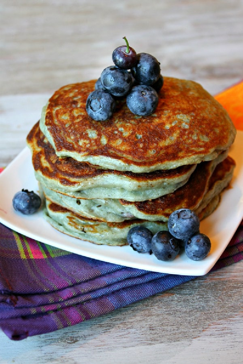 stack of greek yogurt pancakes on a plate with blueberries