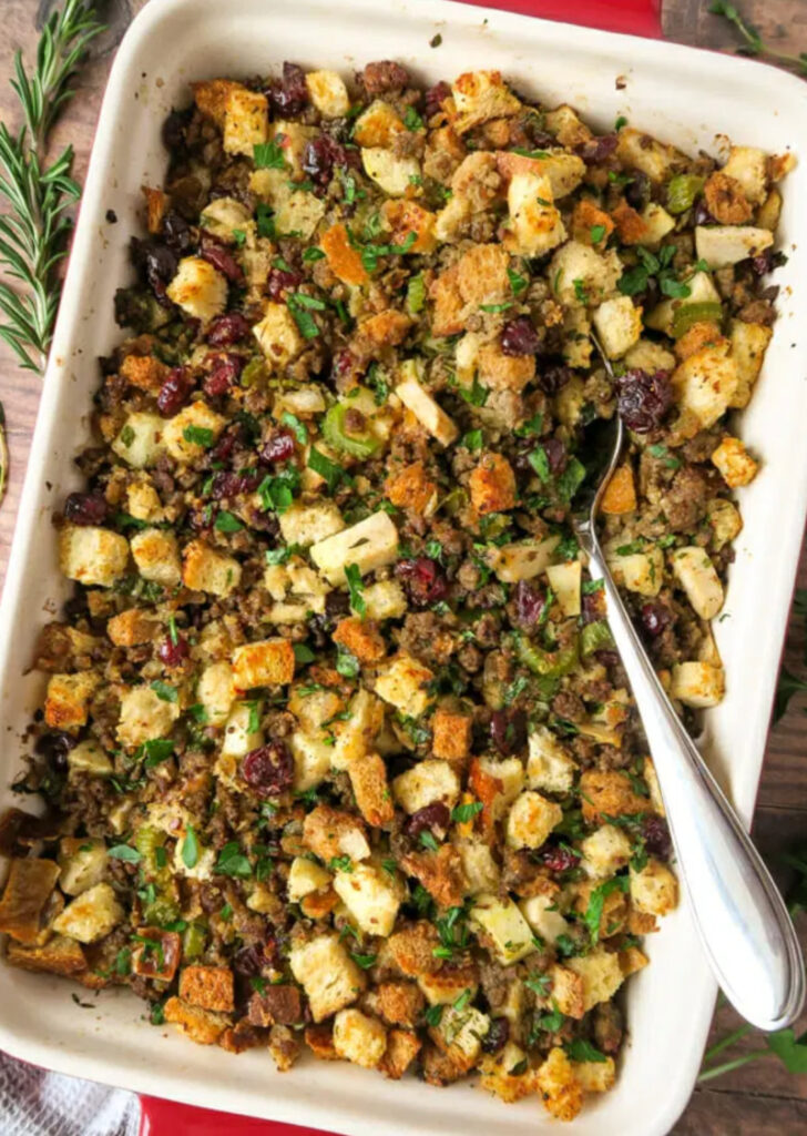 white casserole dish with stuffing and spoon