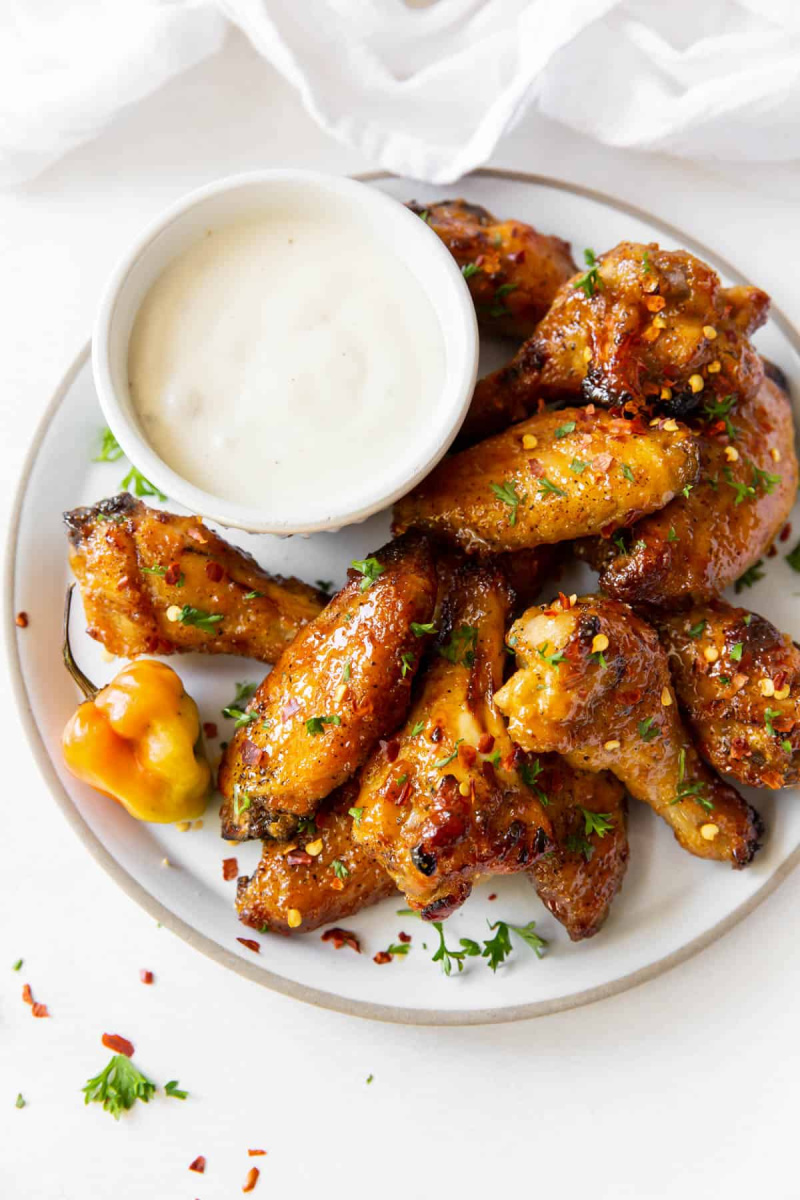 plate of baked mango habanero chicken wings with sauce