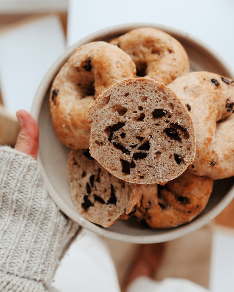 chocolate chip banana bread bagels in bowl with one cut in half