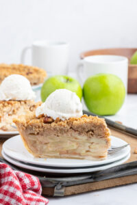 slice of dutch apple pie with scoop of vanilla ice cream on top