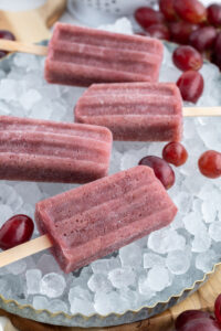 four grape popsicles sitting on ice