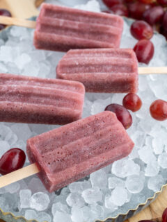 four grape popsicles sitting on ice