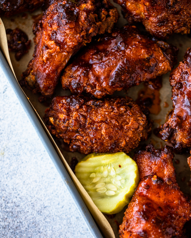 nashville hot chicken wings in pan with pickle