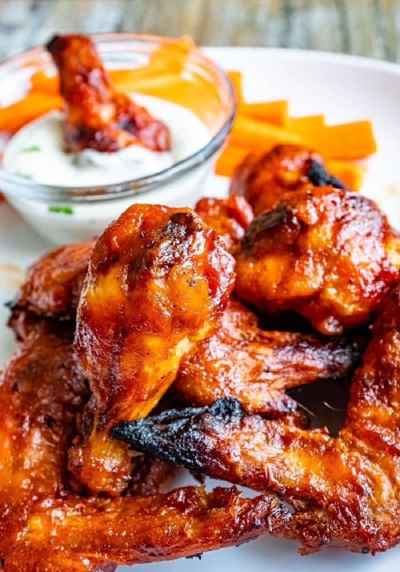 oven baked BBQ chicken wings with bowl of sauce