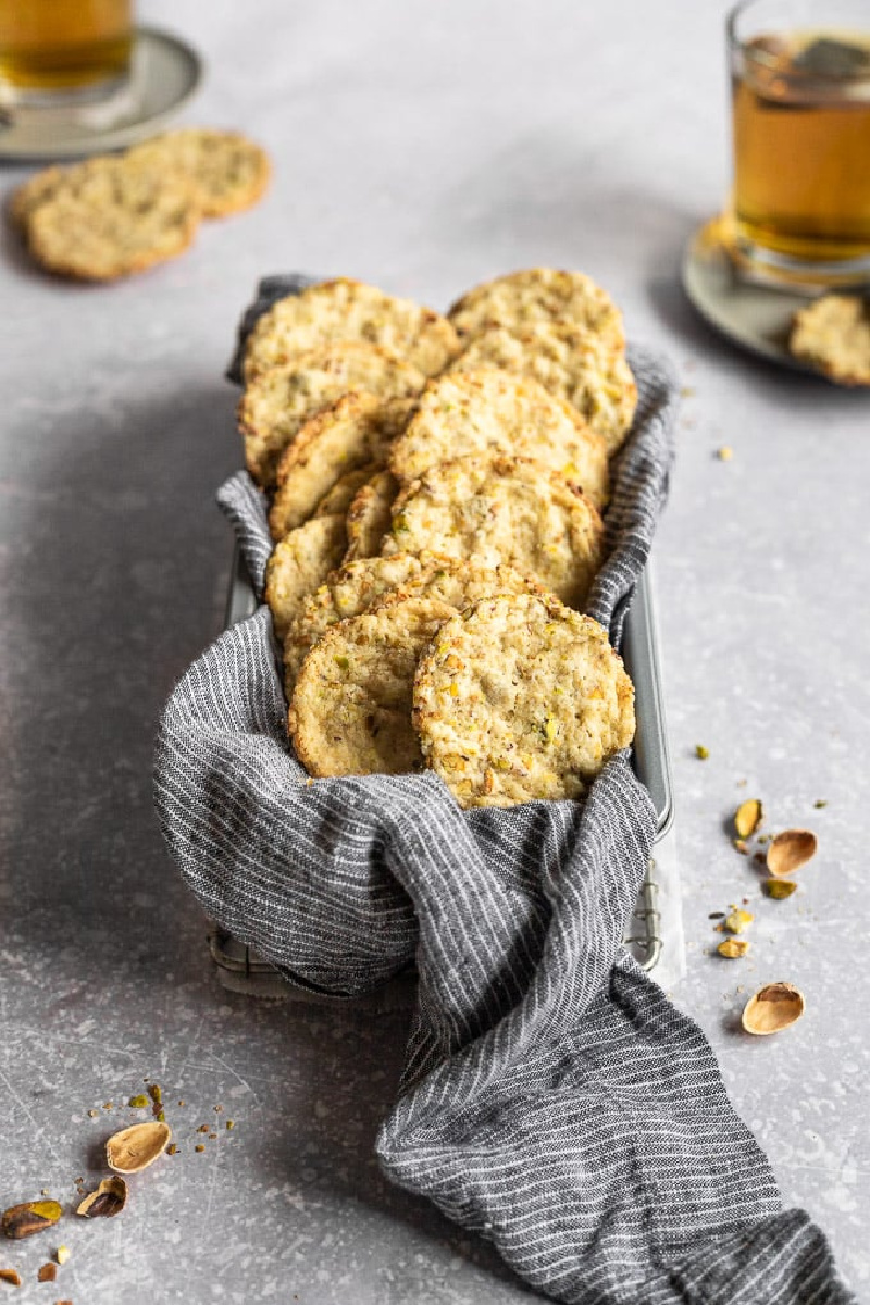 pistachio butter cookies in a basket with a cloth