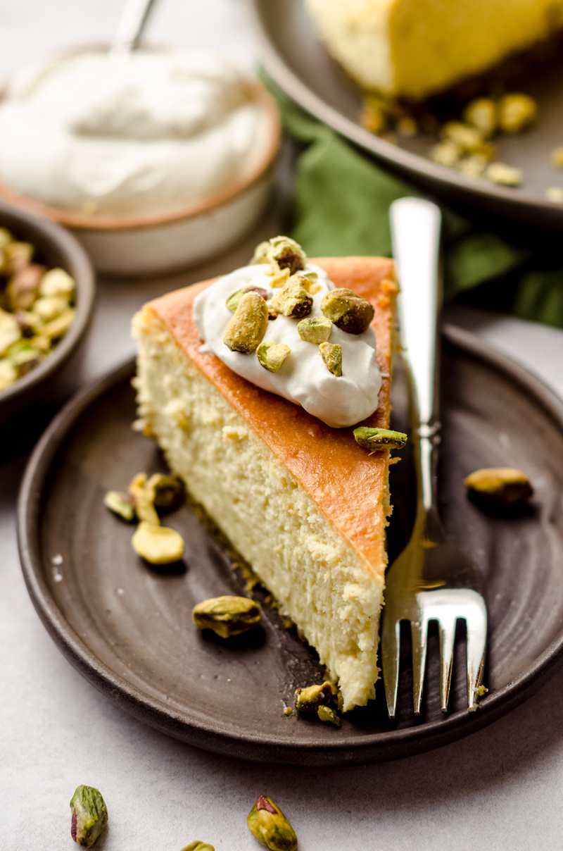 pistachio cheesecake slice on plate with fork