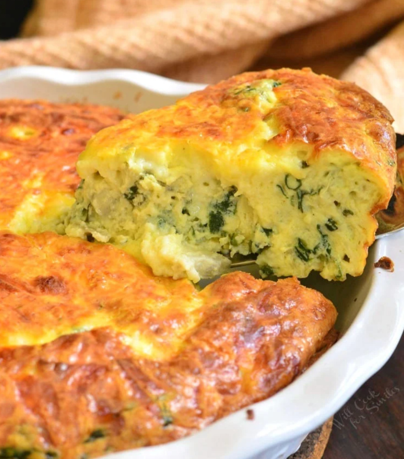 spinach artichoke crustless quiche slice being taken out with spatula