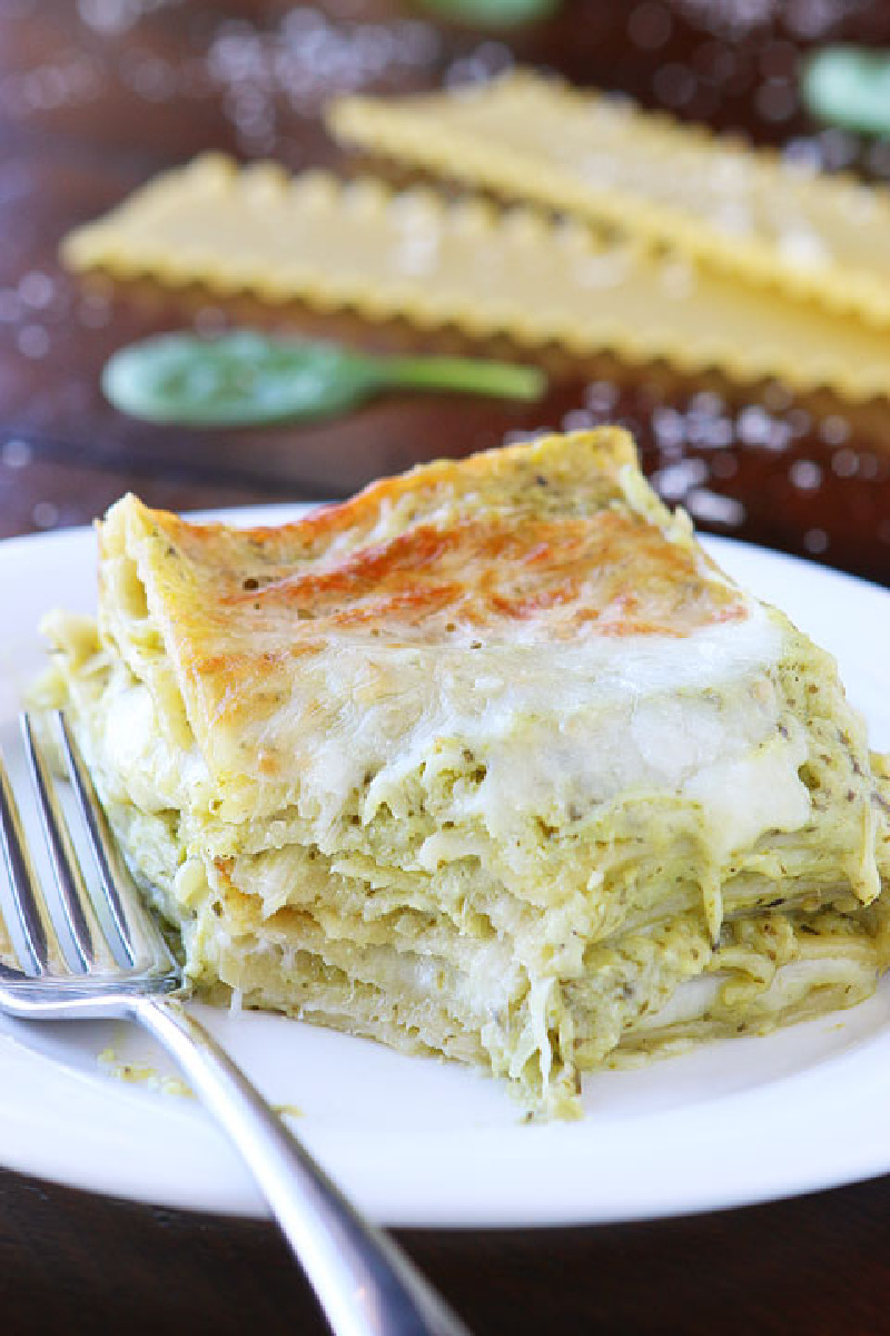 spinach artichoke lasagna on plate with bite out of it