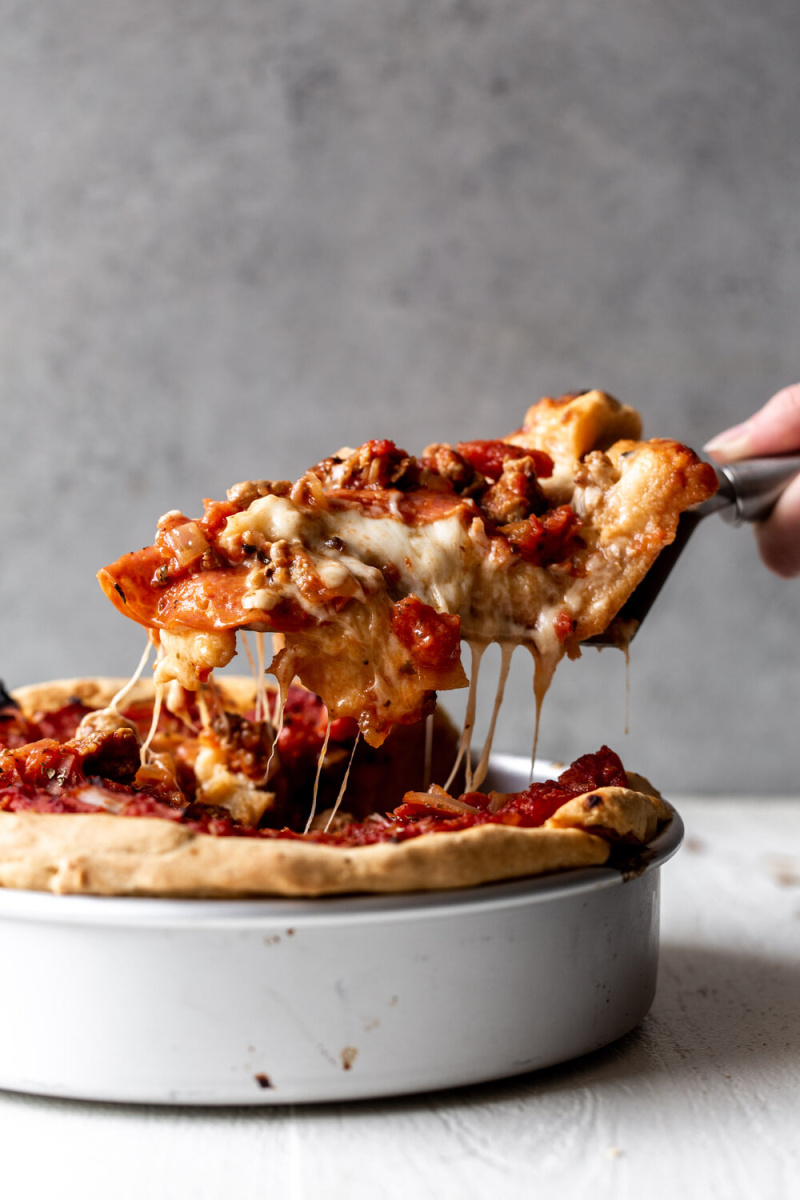 spatula taking out slice of chicago style deep dish pizza out of pan
