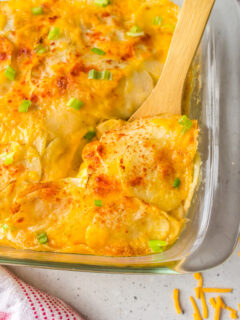 microwave scalloped potatoes in baking dish with wooden spoon