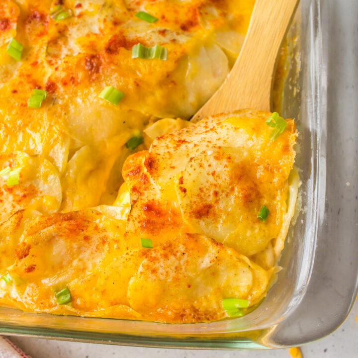 microwave scalloped potatoes in baking dish with wooden spoon