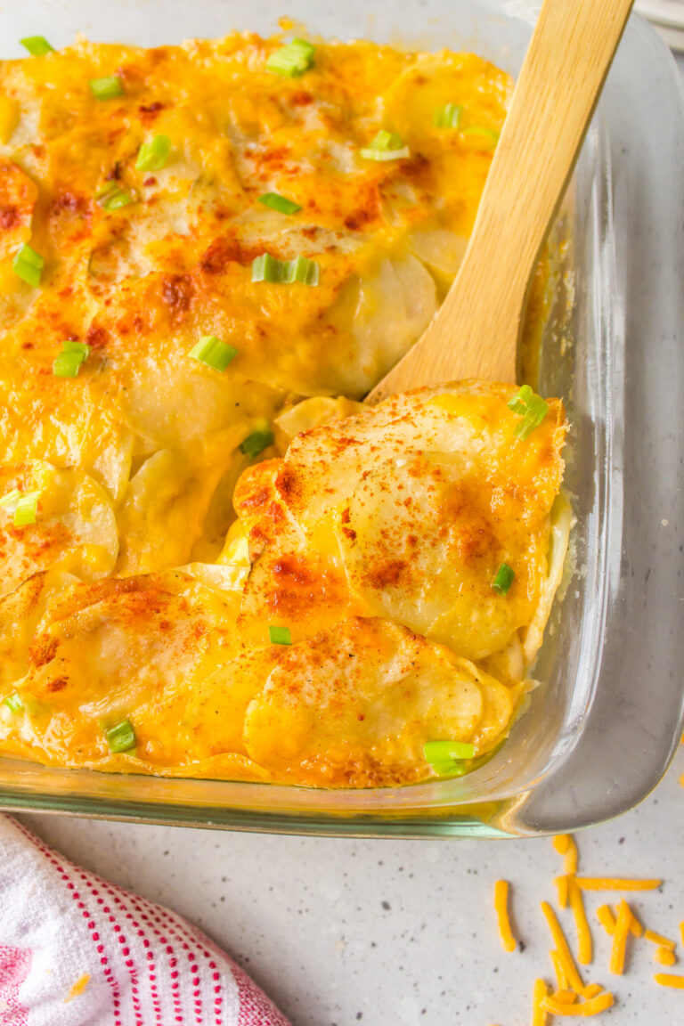 microwave scalloped potatoes in baking dish with wooden spoon