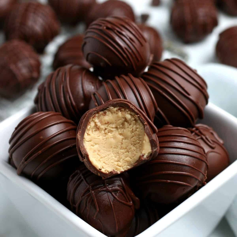 peanut butter fudge truffles in white dish with one bitten into