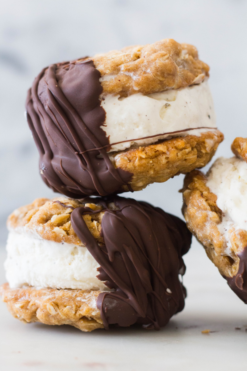 three chocolate dipped oatmeal ice cream sandwiches