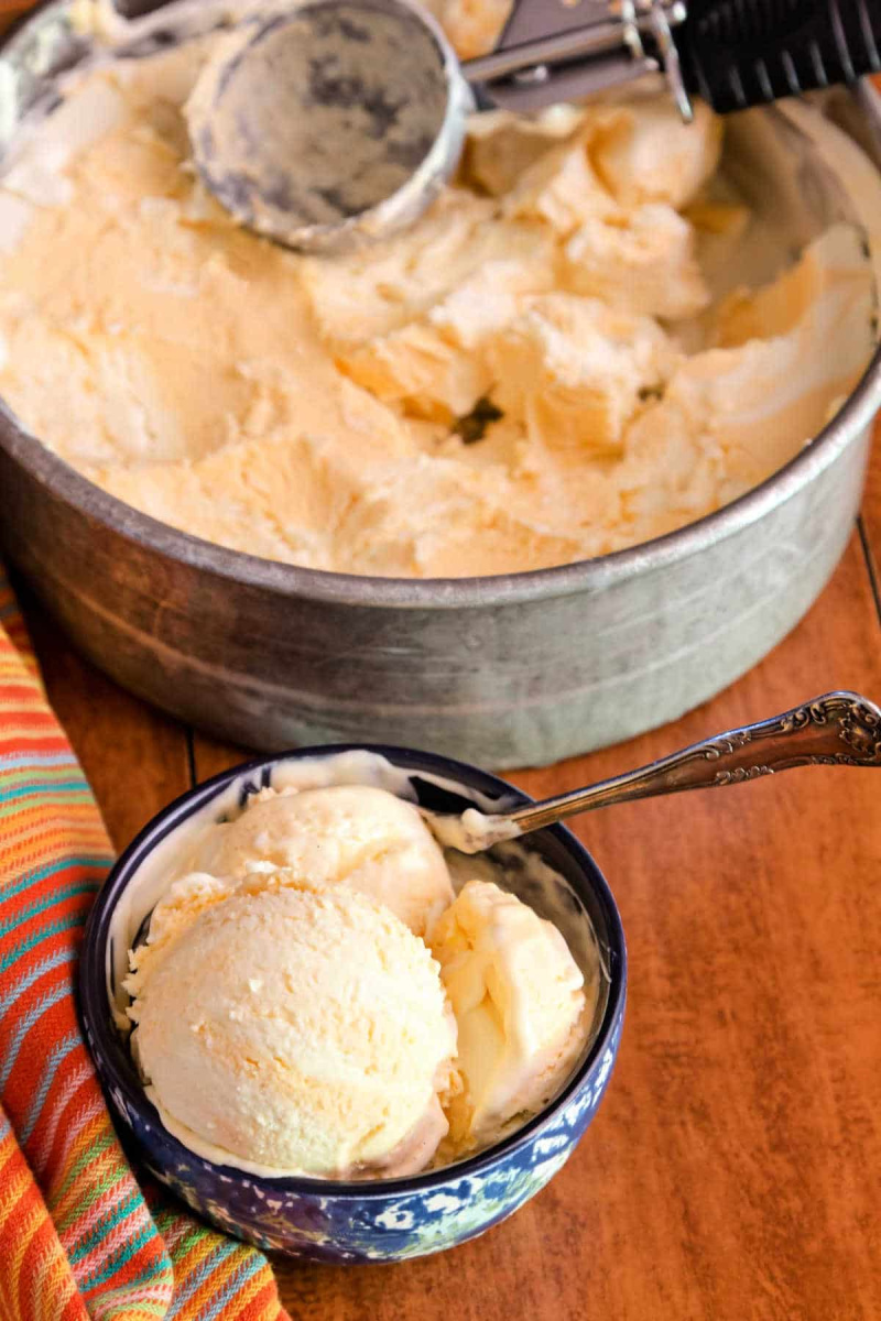 bowl of creamsicle ice cream and container of ice cream in background