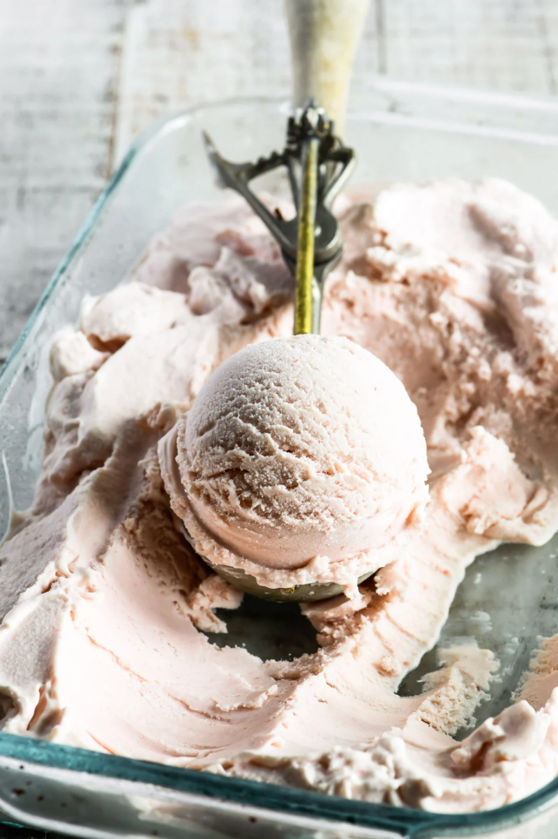 rhubarb ice cream in bin with scoop