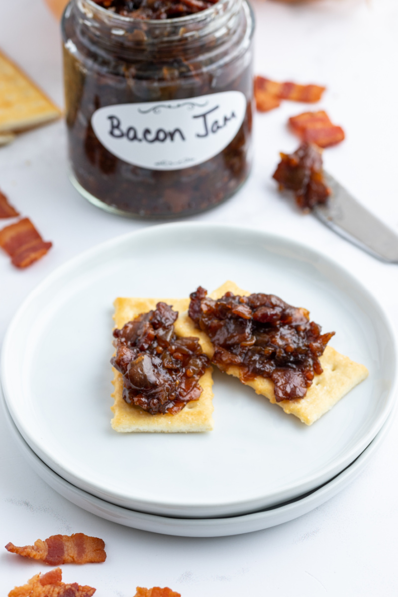 crackers with bacon jam on plate with jar in background
