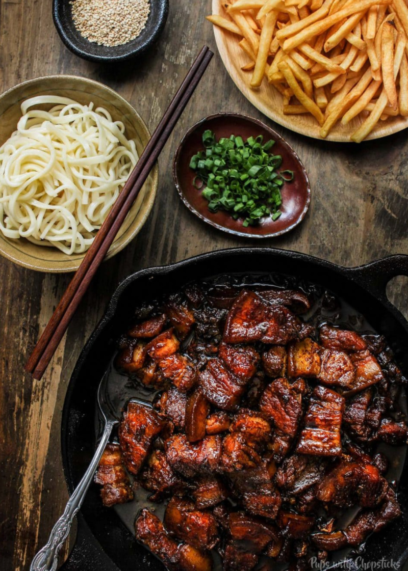 pot of chinese style beer braised pork belly with condiments on the side
