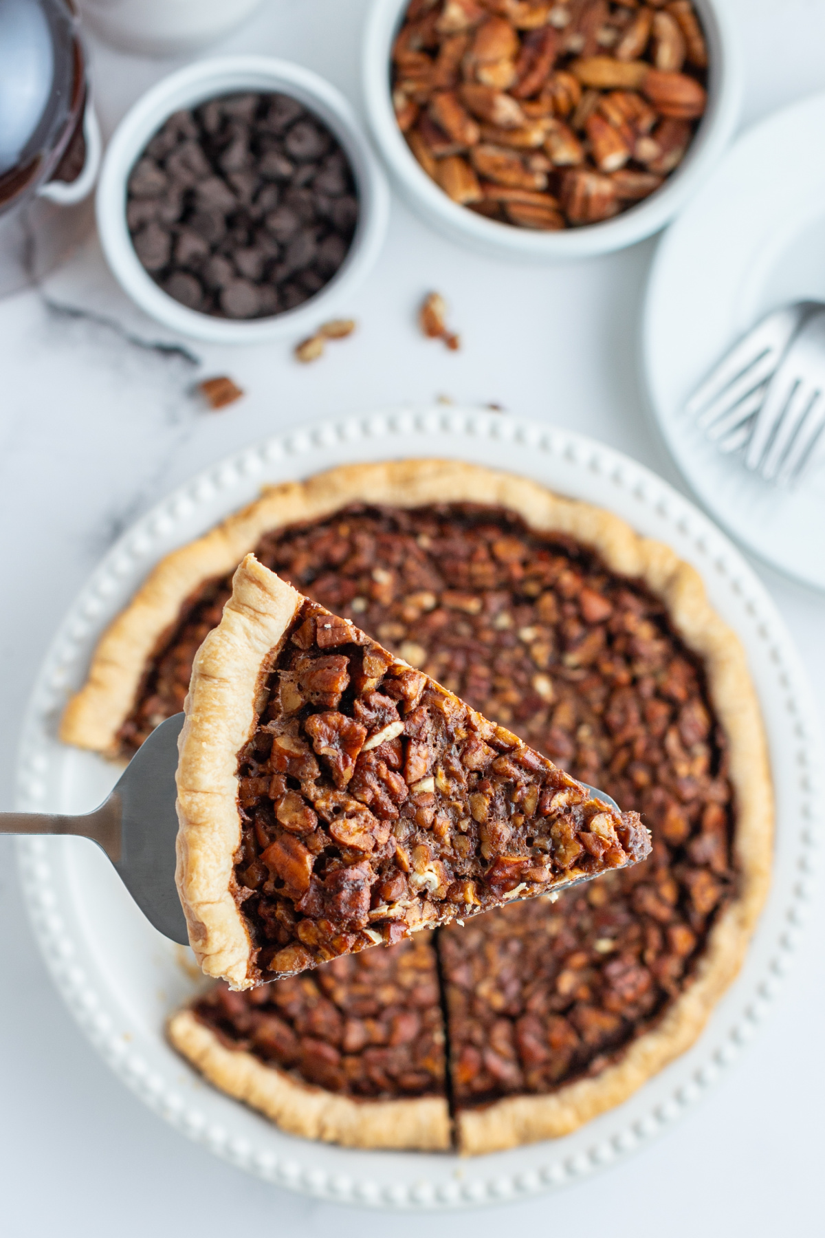 spatula taking out slice of bourbon chocolate pecan pie