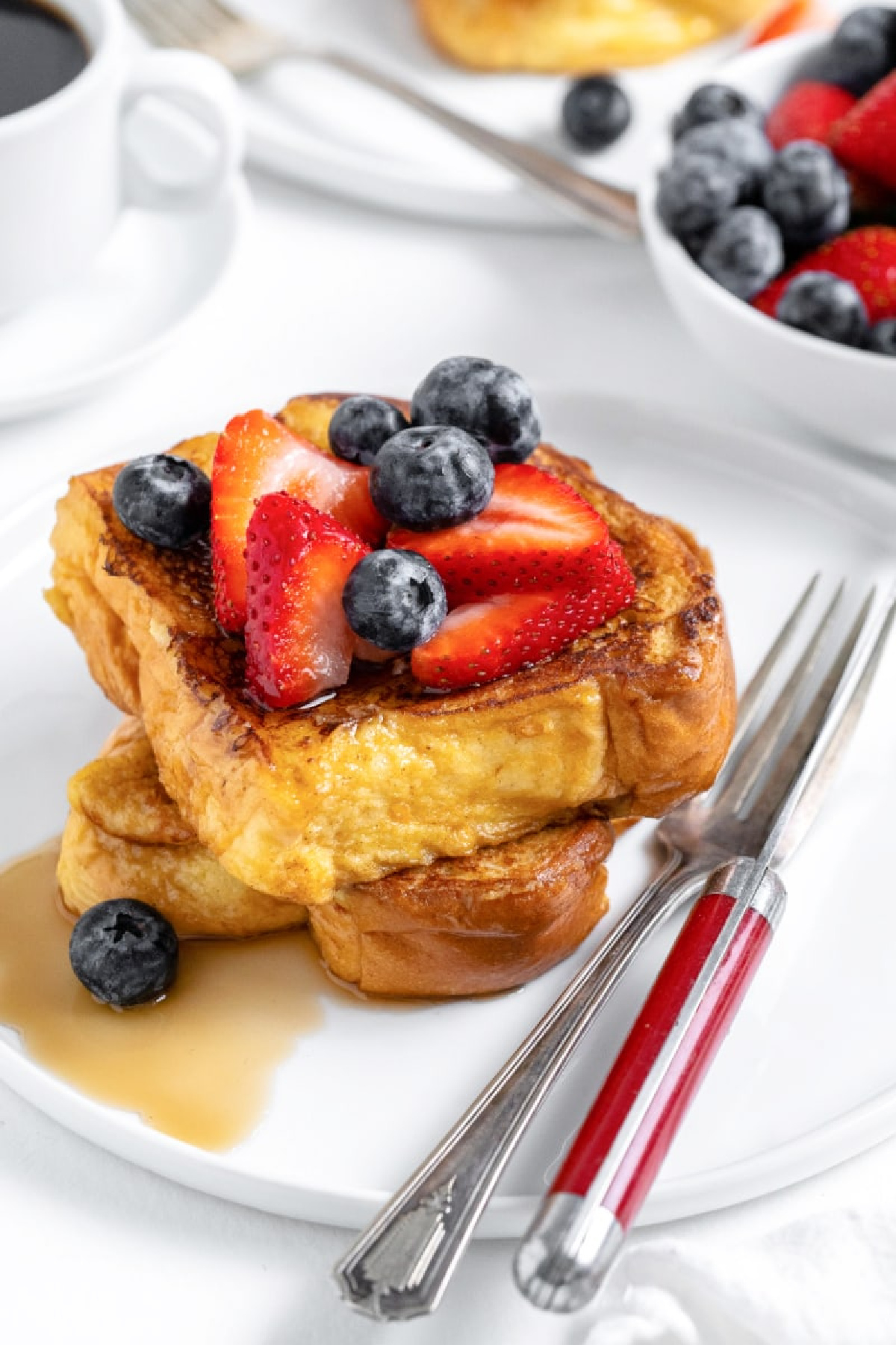 two slices of classic french toast stacked with berries