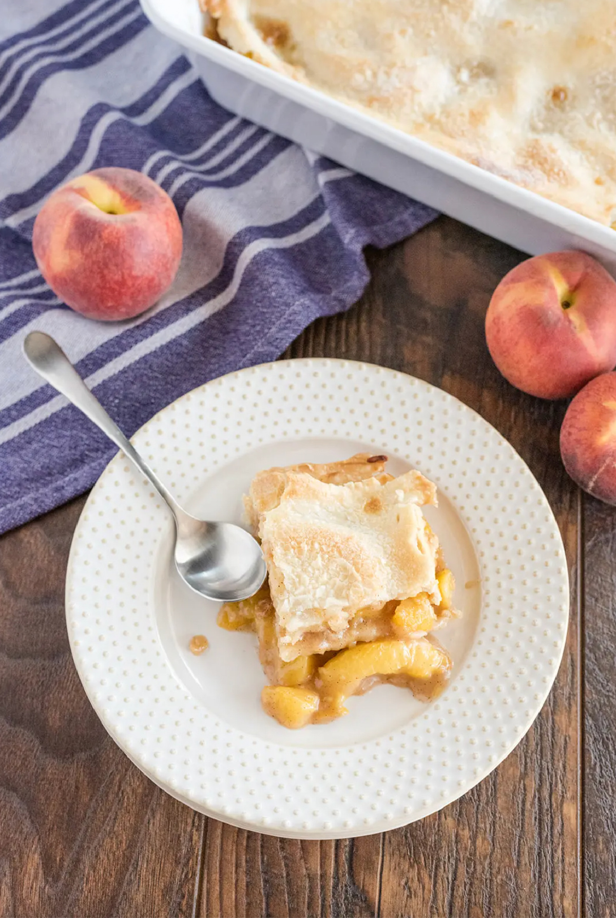 slice of double crust peach cobbler on a plate