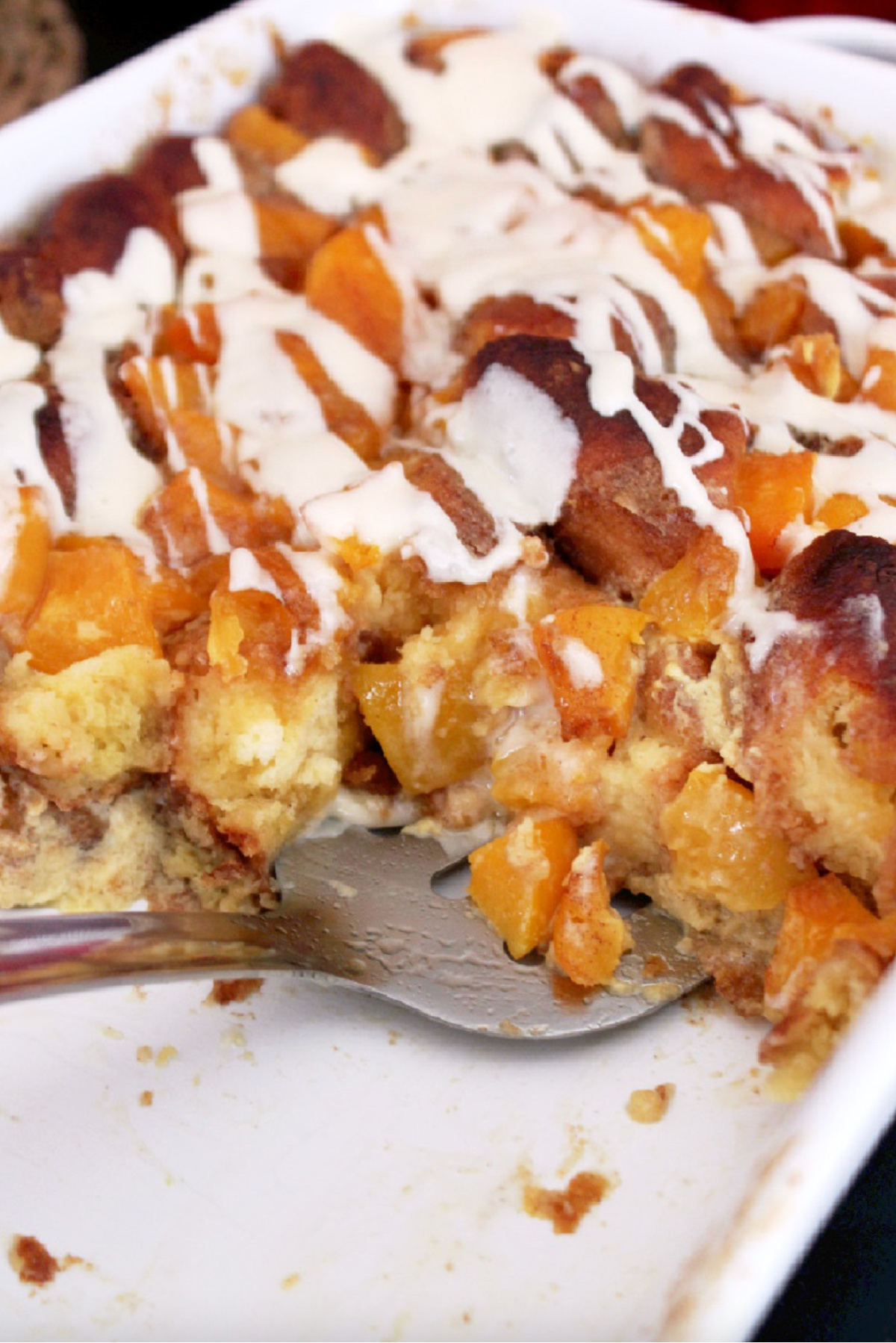 peach cobbler bread pudding in baking dish with serving taken out of it