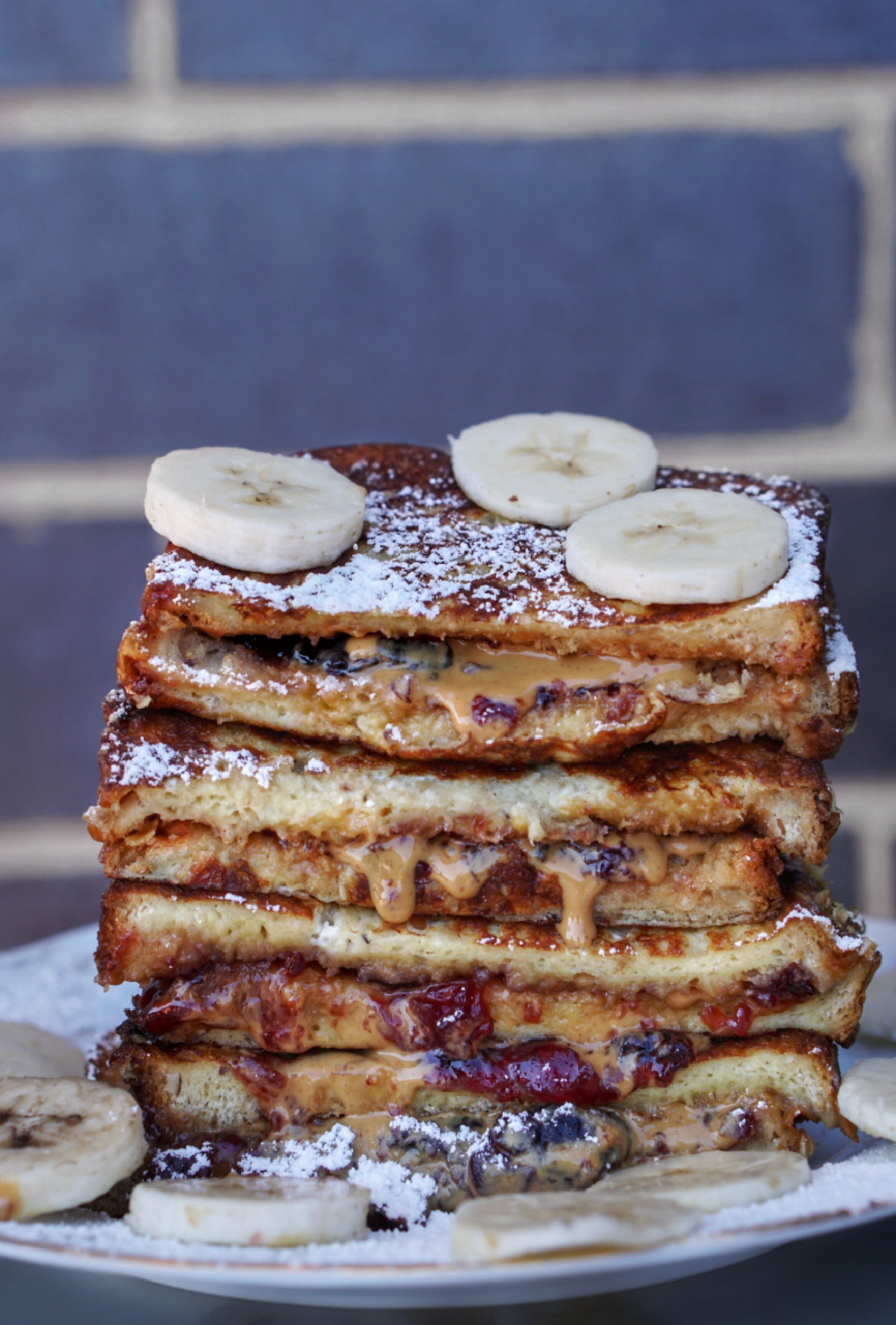 peanut butter and jelly stuffed french toast stacked and topped with bananas