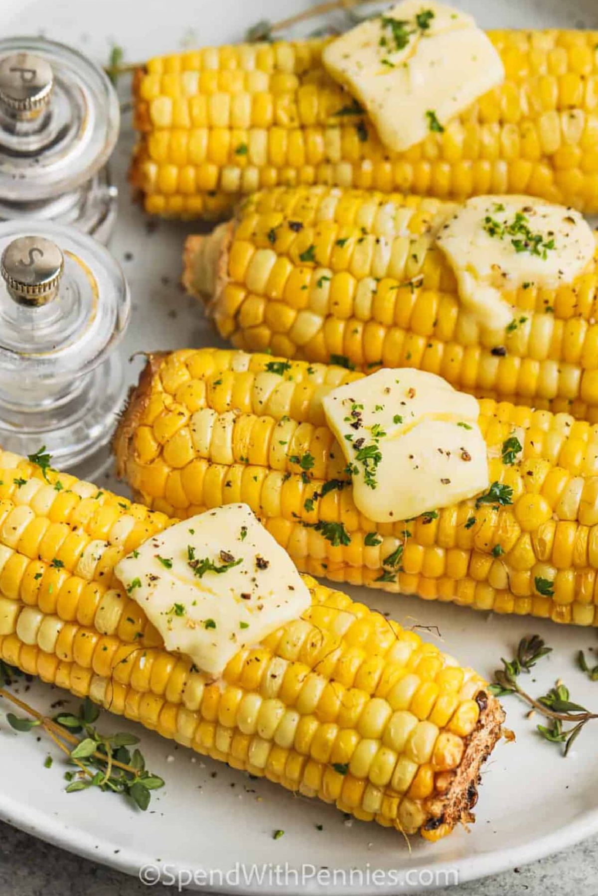 air fryer corn on the cob with pats of butter on top