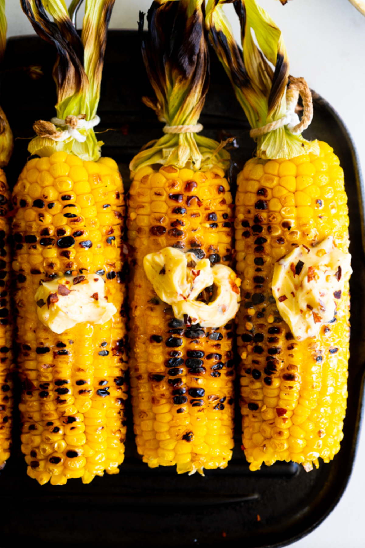 three grilled corn on the cob with hot honey butter