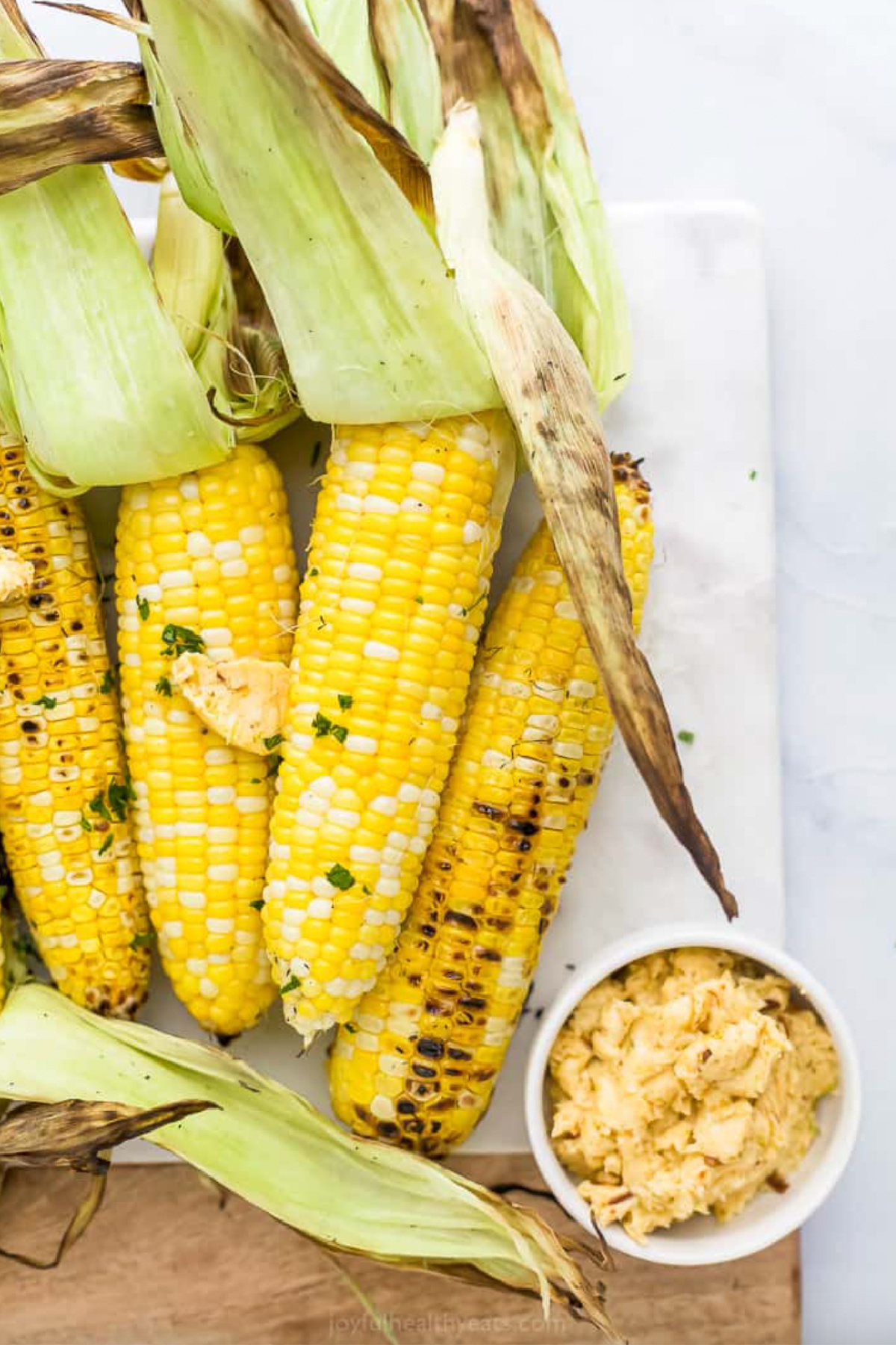 several corn on the cob with husks